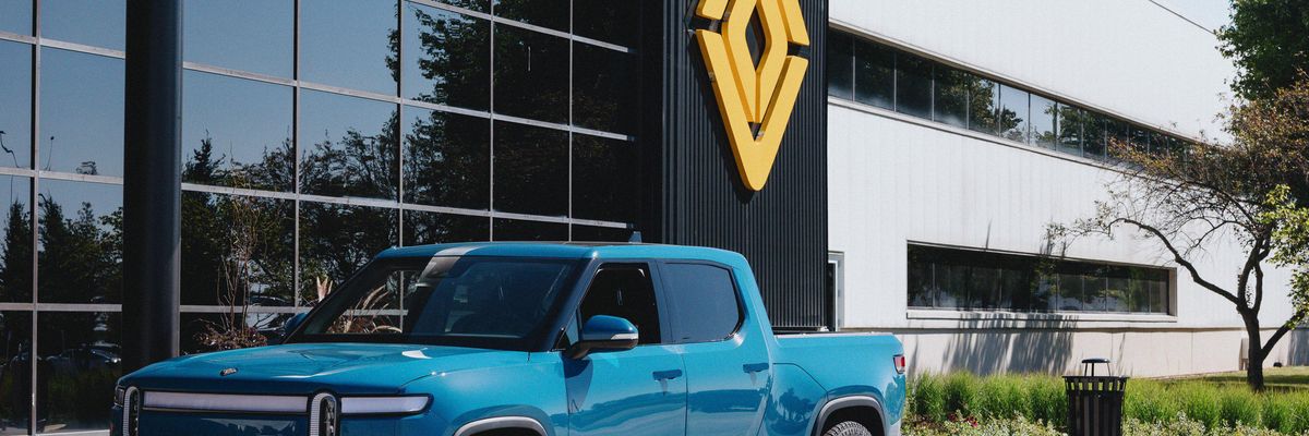 An R1T in Rivian Blue at the main entrance to the plant in Normal, IL.