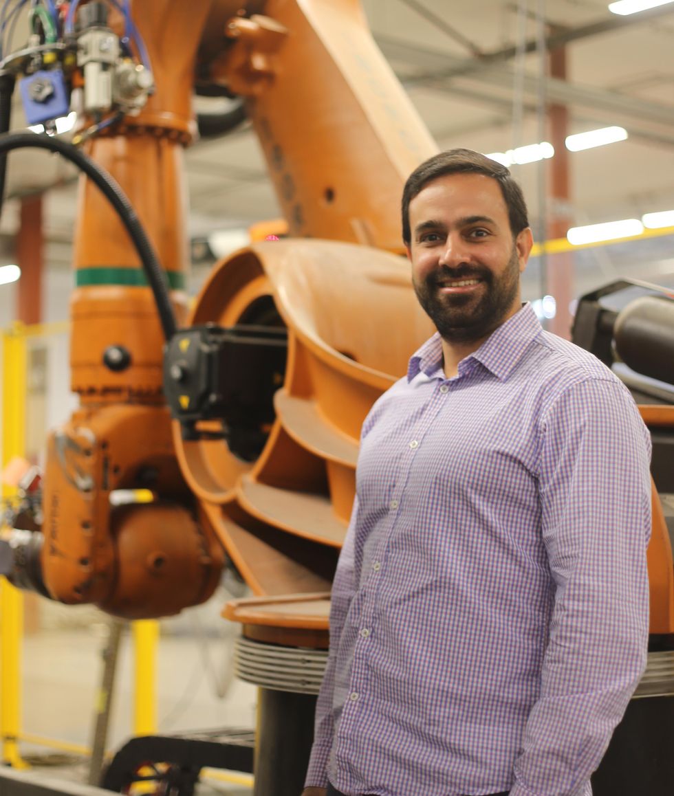 CEO of Machina Labs Edward Mehr stands in front of one of their machines