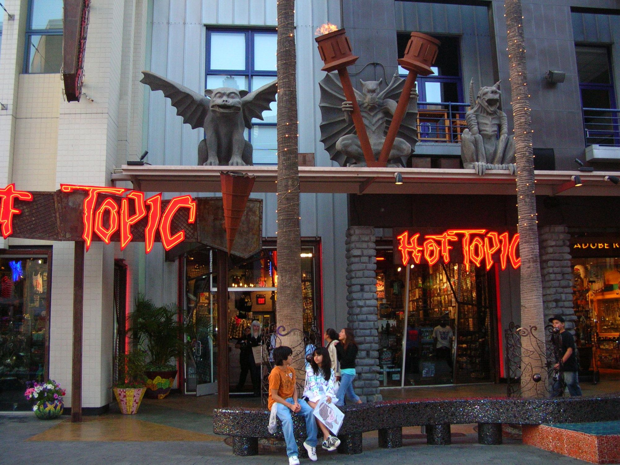 Hot Topic storefront featuring gothic lettering signage lit with red LED lights. 