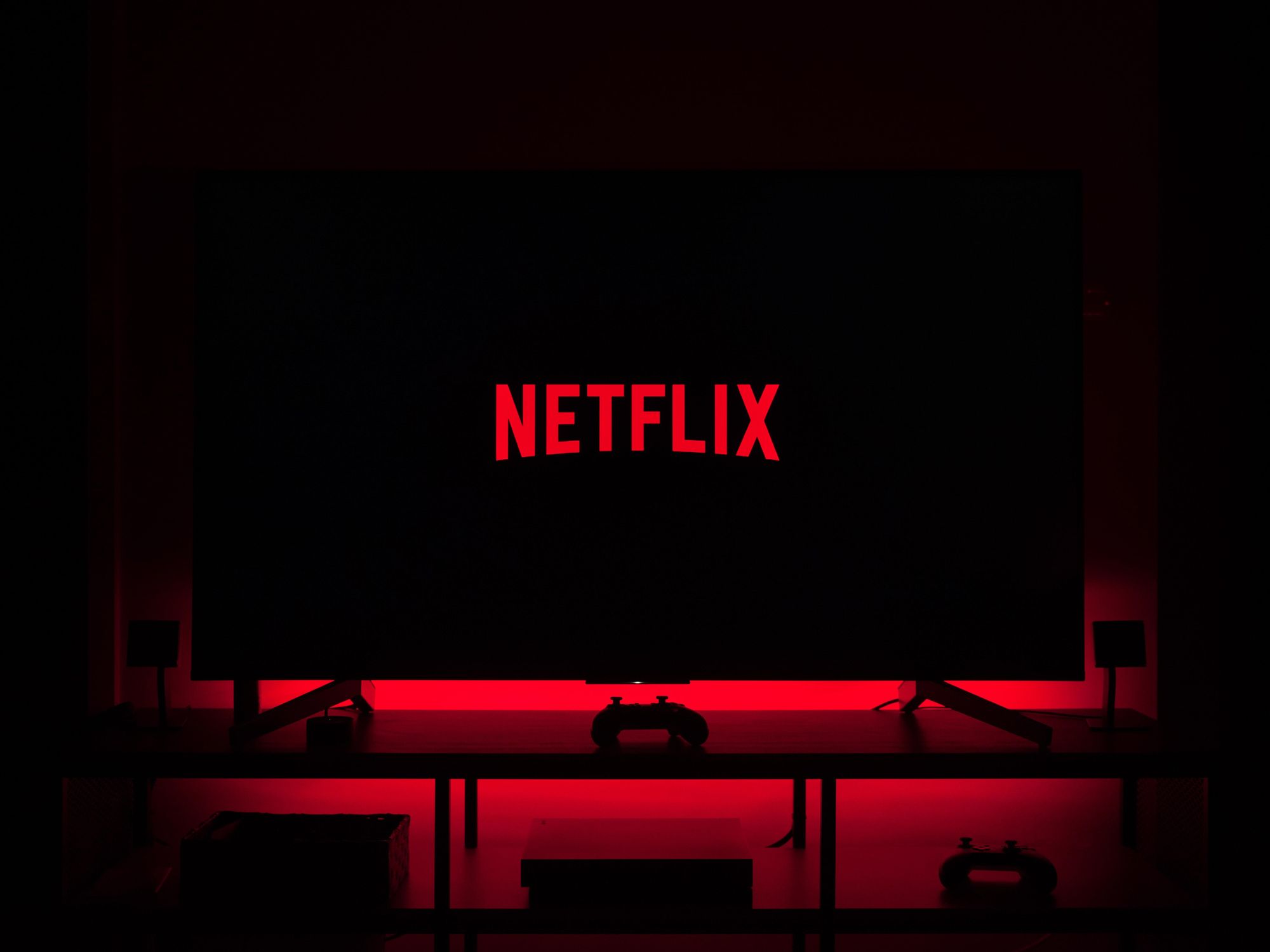 Netflix logo on a TV with red LED backlight behind TV