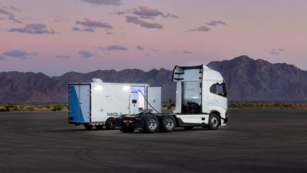 Nikola Truck in an empty parking lot with a mountain in the background.