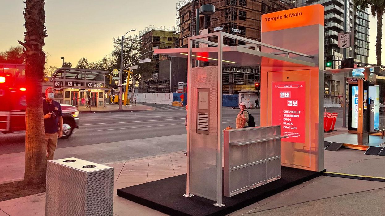 People standing at a Tranzito bus stop hub at the Temple & Main Bus stop.