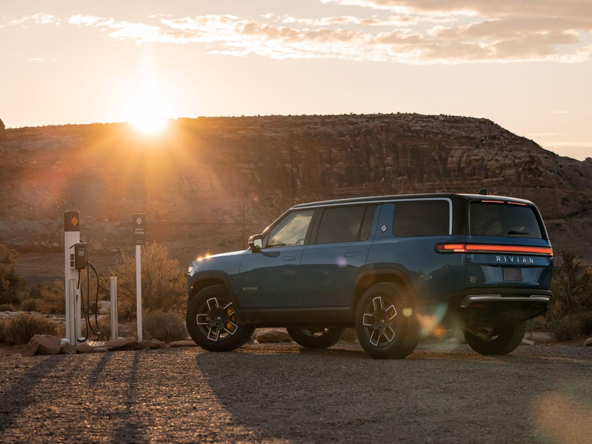 Rivian R1S at a charging station in the desert.