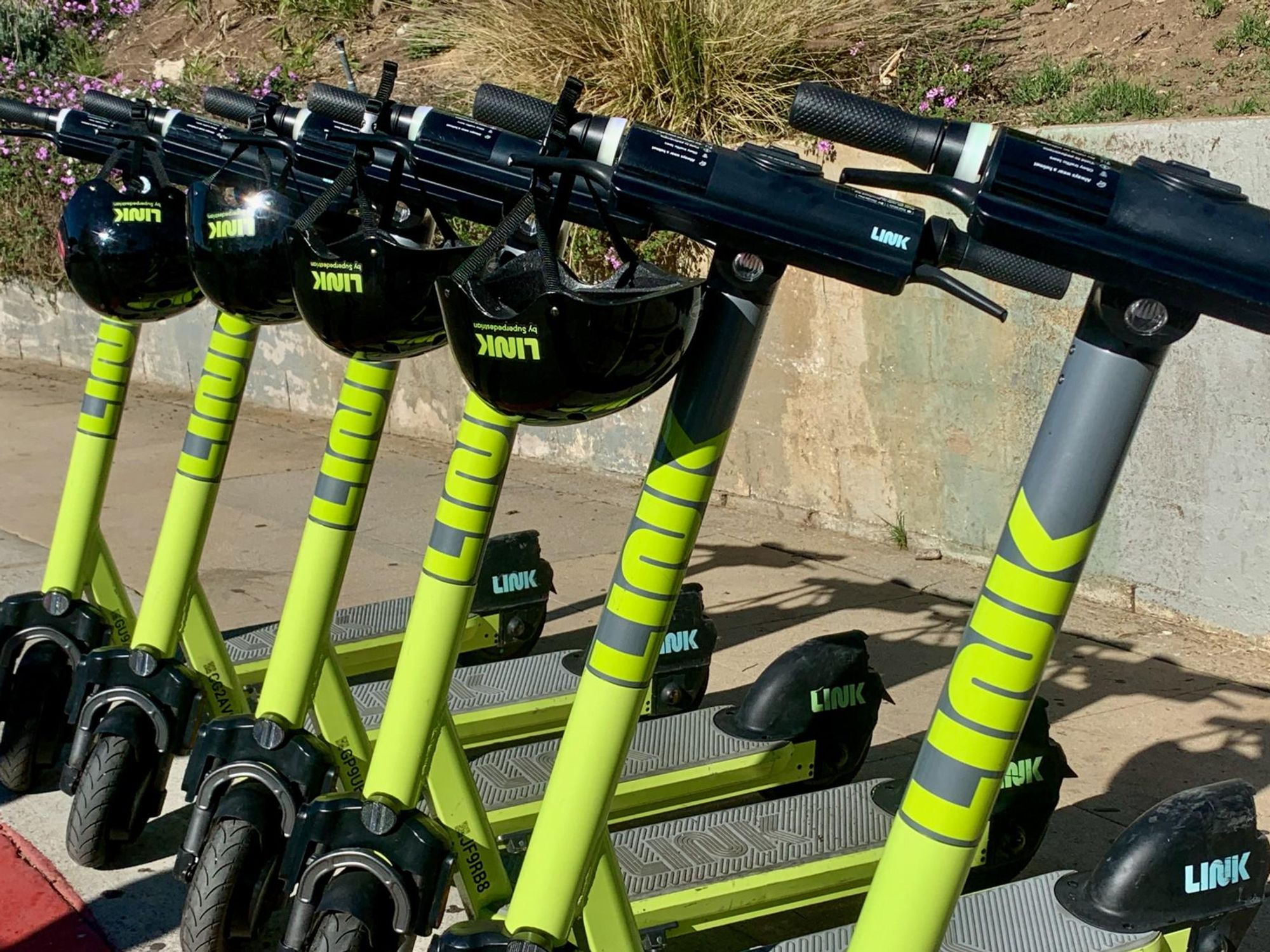 Superpedestrian’s LINK e-scooters on a sidewalk.